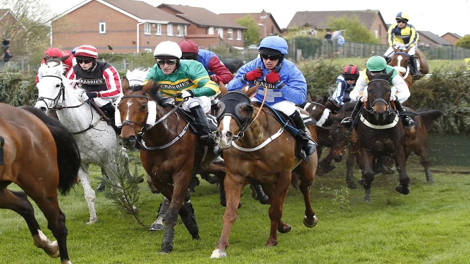 Raz De Maree (ridden by jockey in light blue) running in the Grand National at Aintree